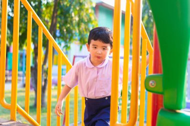 Asyalı çocuk parkta merdivenlerden yukarı gider. büyümenin kavramı.
