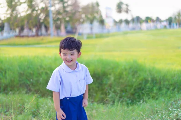 Outdoor portrait of a happy Asian student kid in school uniform — Stock Photo, Image