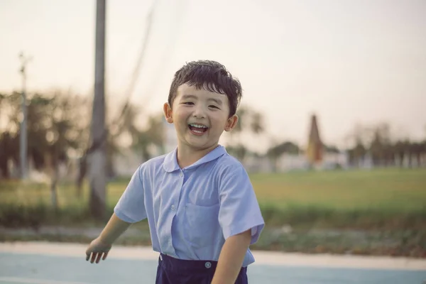 Outdoor portrait of a happy Asian student kid in school uniform — Stock Photo, Image