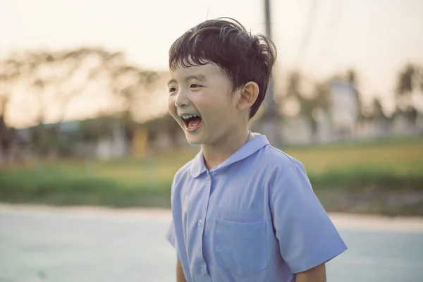 Outdoor portrait of a happy Asian student kid in school uniform — Stock Photo, Image