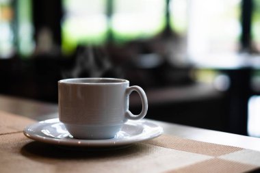 Kahvaltı için restoranda yemek masasında sıcak kahve fincanı.