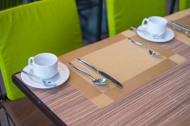 Kahvaltı için restoranda yemek masasında sıcak kahve fincanı.