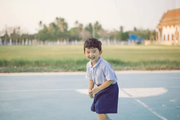 Outdoor portrait of a happy Asian student kid in school uniform — Stock Photo, Image