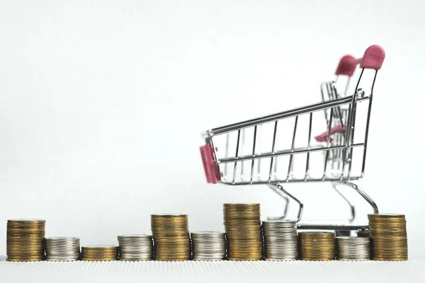 Стопки монет і кошик для покупок або візок для супермаркетів, бізнесмен — стокове фото