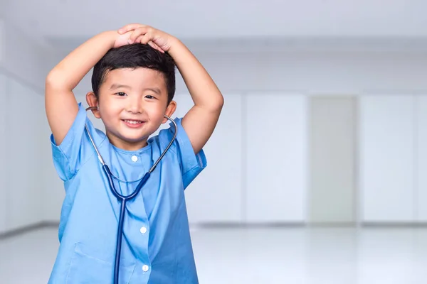 Lachende Aziatische jongen in blauwe medische uniform holding stethoscoop lo — Stockfoto