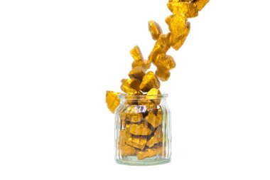 Düşen altın külçeleri veya altın cevheri ve cam kavanoz beyaz izole