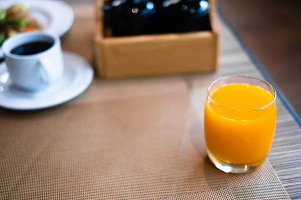 Glass of orange juice on table in restaurant for breakfast. — Stock Photo, Image