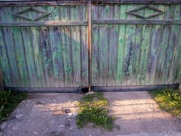 Strong textured old wooden gate with painting peeling off, in a small village in Transylvania.