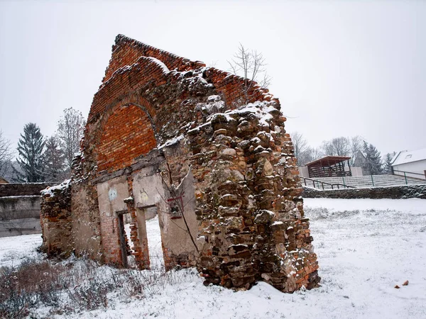秋の雪の中でレンガ造りの古いピーク 三角形の建物の遺跡 — ストック写真