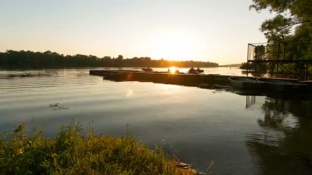 船停泊在日落 河上日落 船码头 人们登上码头和运输在日落 船停靠在日落的河流上 — 图库视频影像