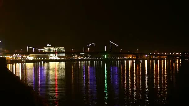 夜照在桥上 美丽的桥在夜色中照亮了城市的夜景 夜时的天桥 基辅的行人桥在河边的 Dnepr 在夜色中倒映在水中 — 图库视频影像