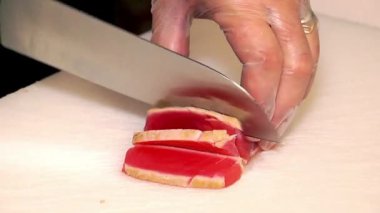 Şef somonu kesiyor, somonu kesiyor, balığı bıçakla kesiyor, somonu iştah açıcı somon yiyor, Şef mutfakta duruyor, somon balığı kesiyor, somon filetosu dilimliyor. 