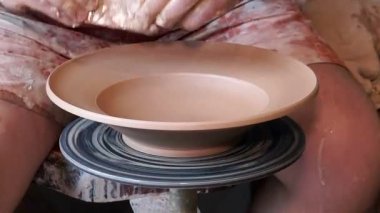 Toprak kap şekillendirme çömlekçilik direksiyonda çalışma Potters tekerlek, el formları toprak kap potter's tekerlek, deneyimli usta bir tabak çanak çömlek direksiyona yapıyor üzerinde eller, eller kil tabak çanak çömlek atölyesinde bitiş dokunur musun