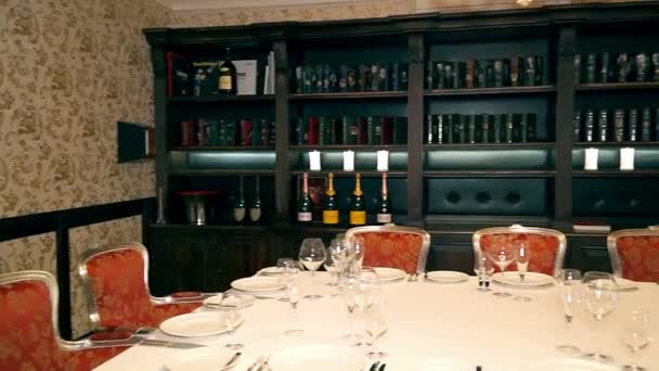レストランのテーブルを提供して テーブルでワインのボトルの中でレストランを提供しています休日の準備添えテーブル数人のためレストランで周りの椅子 — ストック動画