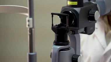 göz testi, tıbbi Biyomikroskop aygıt lazer Parlatıcı göz, phoropter göz hastalıkları kliniği kadın hastaya inceleyerek Optometrist içinde,