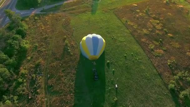 在日落时起飞气球 在夏天的日落时开始从草地上飞起来 在夏天的傍晚 气球和人一起在田野上飞行 — 图库视频影像