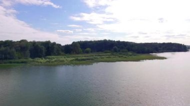 nehir, nehir kıyısına, yukarıda operasyonlarla çimenli banka havadan görünümü ile büyümüş gür nehir, nehir kıyısına 4 k hava görünümünü boyunca derin ve geniş yeşil nehir çarpıcı yukarıda uçan