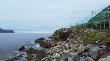 Lofoten ağları ile taşlı kıyı boyunca uçuş, Norveç kıyılarının havadan görünümü, Norveç'te somon Çiftliği balıkçılık üzerinde uçuş, Norveç Denizi'nde somon çiftliği ağı
