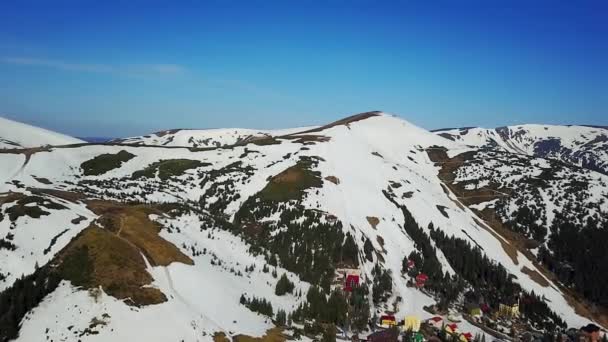 山の雪に覆われた村の冬 空中ビューで山の村の空撮 — ストック動画