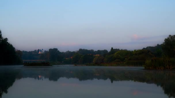 橋と教会を背景に夜明けの川の時間経過 日の出時の川の時間経過 日の出時の朝霧 霧の中の川の上の夜明けの時間経過 — ストック動画