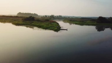 gündoğumu üzerinde teknede balıkçı havadan görünümü, sabah balıkçılık, şafak sis sakin bir nehirde teknede yüzme bir kürek ile yalnız adam