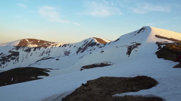 夕暮らしの雪に覆われた山腹 夕日に照らされた山頂 冬のカルパチア山脈の夕日 冬の山々の斜面 冬の風景 — ストック動画