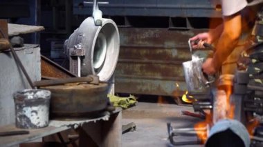 Fabrikada metal parçalarının ateşlenmesi, fabrikadaki fırının parçalarının sertleşmesi, erkek işçinin fabrikaya çelik bloklar atması, gaz ocağıyla metal yakması...