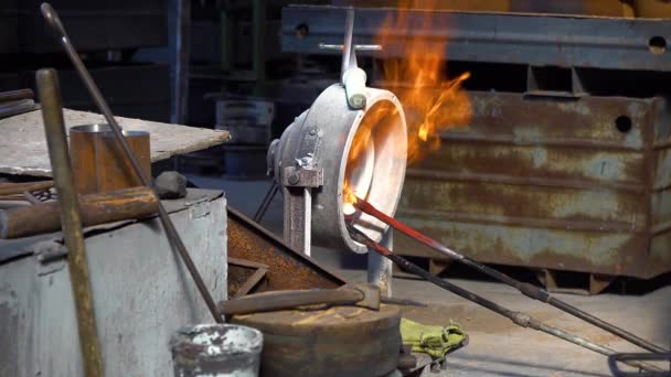 工場内の金属部品の焼成 工場内の炉内部品の硬化 工場内の男性労働者による燃える鋼ブロックの焼成 ガスバーナーを用いた金属アニーリング — ストック動画
