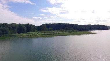 Nehrin otlak kıyısı, nehir kıyısının üzerinde uçuyor, sersemletici derin ve geniş yeşil nehrin üzerinde uçuyor, nehir boyunca, 4k nehir manzarası boyunca,, 