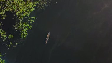 Güneşin doğuşunda nehir üzerindeki teknenin havadan görünüşü, nehirde gün doğumu, gün doğumunda teknede balıkçı, sabah balıklarının havadan görüntüsü, gün doğumunda motorlu teknenin üzerinden uçmak.
