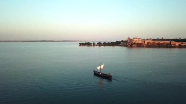 Günbatımında eski yelkenli gemisinin hava manzarası, günbatımında eski yelkenli gemisinin havadan görüntüsü kalenin arka planında, günbatımında eski yelkenli gemisinin silueti.