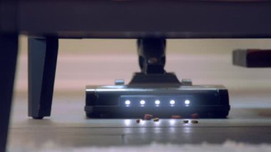 Döşemeleri süpürüp, yerleri süpürüp, evi temizleyip, kanepenin altını süpürüp, zemini yavaş çekimde süpürüyor.