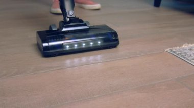 Döşemeleri süpürüp, yerleri süpürüp, evi temizleyip, kanepenin altını süpürüp, zemini yavaş çekimde süpürüyor.