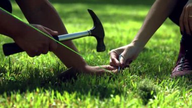 Takunya askıları, çekiçler çadırda, çadır kurulacak yakın plan, çadır son ayarı.