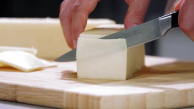 Şef peyniri keser, peyniri yavaş çekimde keser, peyniri yakın çekimde keser.