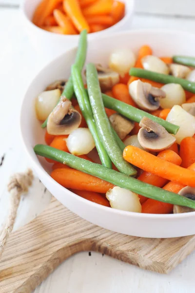 Vegetarian cuisine. Stewed vegetables: carrots, green beans, braised onion with mushrooms
