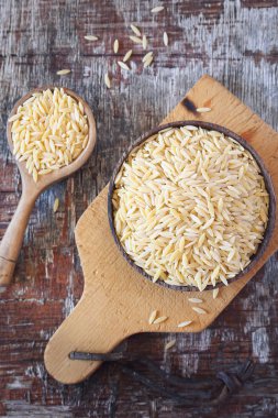 Gıda katkı maddeleri. Ahşap kase çiğ risoni makarna. Üstten Görünüm