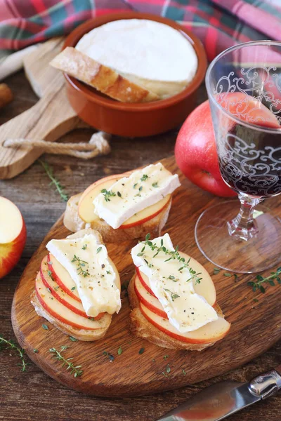 Manzanas y queso Camembert pan tostado y copa de vino tinto — Foto de Stock