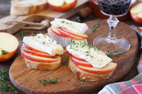 Apples and Camembert cheese bread toast and glass of red wine