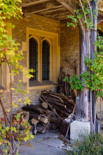 İngiltere 'de eski bir Tudor malikanesinin gölgeli köşesinde bir odun yığını