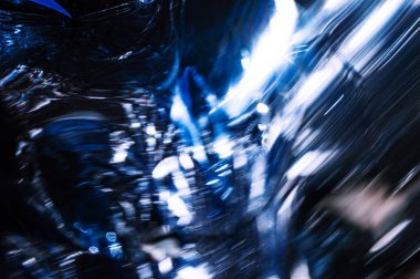 Kontrast güneş ışık yansımaları ile holografik plastik kırışık film. Metalik krom yüzeyinde koyu siyah gölgelerle mavi tonları. Neon ışık renkleri. Soyut fantezi trendy psychedelic arka plan 