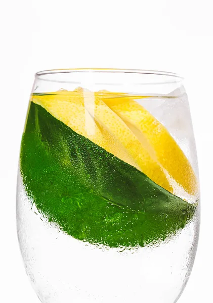 Vaso húmedo con agua y limón. Hoja de limonero. Bebida caliente. Fondo de alimentos orgánicos saludables. Foto limpia minimalista brillante. Iluminación de luz solar. Vitamina C elemento nutricional corporal . —  Fotos de Stock