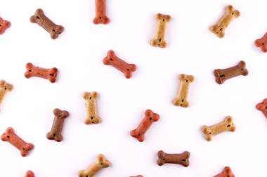 Kemik şeklinde kuru atıştırmalıklarla yapılmış köpek maması desenleri. Komik düz yüz dokusu. Ev hayvanları, hayvanlar besleniyor. Özel diyet, eğitim desteği.