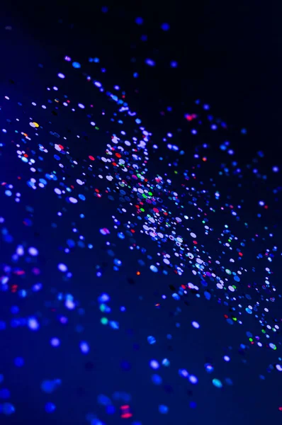 Colorful lights blurred glitter background. Abstract illuminated texture. Christmas, new year or birthday celebration. Night life photography