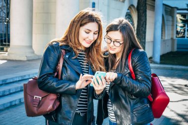 Yaşam tarzı, resme onlar üzerinde en iyi arkadaş kızlar loking güneşli görüntüsünü smartphone, mutlu tatiller, alışveriş günü.