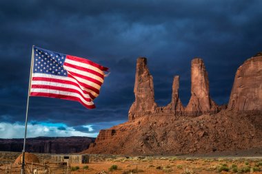 Amerikan bayrağı fırtına içinde belgili tanımlık geçmiş, Monument Valley, Arizona, ABD ile rüzgârda çırpınıyor.