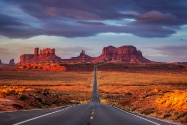 Monument Valley, Arizona, ABD yakınındaki pembe, altın ve kırmızı renklerle şaşırtıcı gündoğumu.