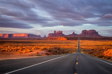 Monument Valley, Arizona, ABD yakınındaki pembe, altın ve kırmızı renklerle şaşırtıcı gündoğumu.
