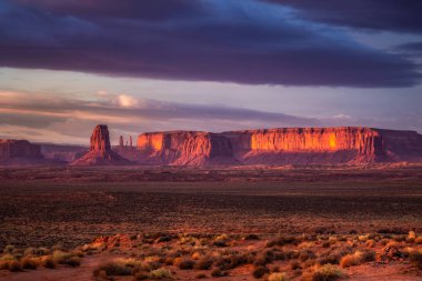 Monument Valley, Arizona, ABD yakınındaki pembe, altın ve kırmızı renklerle şaşırtıcı gündoğumu.