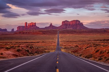 Monument Valley, Arizona, ABD yakınındaki pembe, altın ve kırmızı renklerle şaşırtıcı gündoğumu.